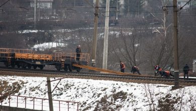 Рабочие у путей рядом с составом из платформ зимой