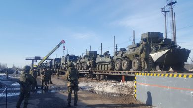 Военнослужащие у погрузочной рампы с колёсной техникой на платформах