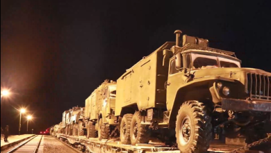 Военные грузовики на платформах воинского эшелона ночью