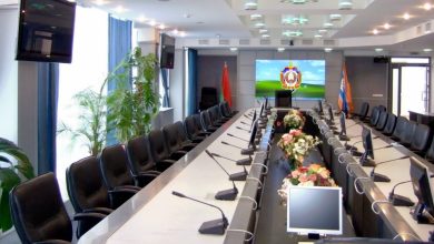 Пустой зал заседаний с длинным столом и экраном