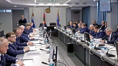 Участники итогового совещания за длинным столом