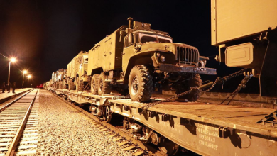 Военные грузовики на платформах воинского эшелона ночью