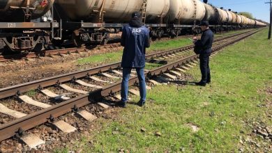Двое сотрудников у путей рядом с составом из цистерн