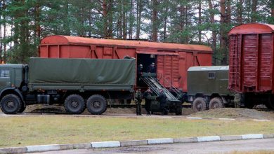 Армейские грузовики у крытых вагонов на погрузочной площадке в лесу