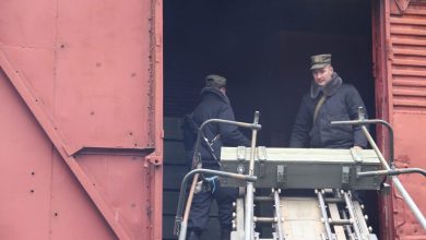 Военнослужащие у открытого вагона, ящики с боеприпасами на роликовом транспортёре