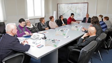 Участники встречи за столом в кабинете со схемой железных дорог на стене
