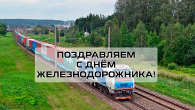 Контейнерный поезд с электровозом на перегоне, надпись «Поздравляем с Днём железнодорожника!»