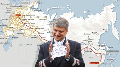 Мужчина в форме железнодорожника аплодирует на фоне карты железных дорог России