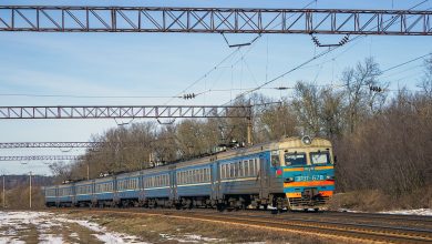 Электропоезд ЭР9Т на перегоне под контактной сетью ранней весной