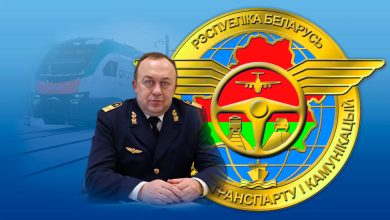 Мужчина в форме на фоне эмблемы Министерства транспорта и коммуникаций Беларуси