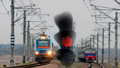 Два электропоезда на перегоне, на переднем плане светофор с красным огнём