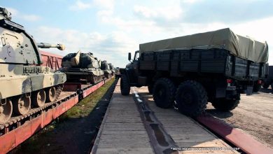Самоходные гаубицы на платформах и армейский грузовик на погрузочной рампе