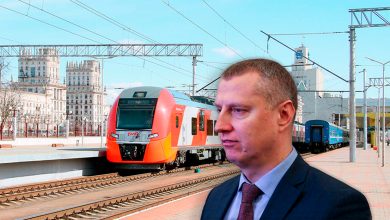 Мужчина в костюме на фоне электропоезда «Ласточка» у вокзала