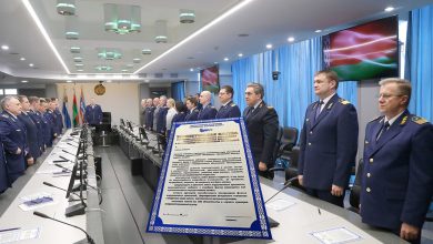 Железнодорожники в форме стоят в зале заседаний, на переднем плане документ в рамке