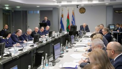 Совещание в зале заседаний: участники за длинным столом, флаги