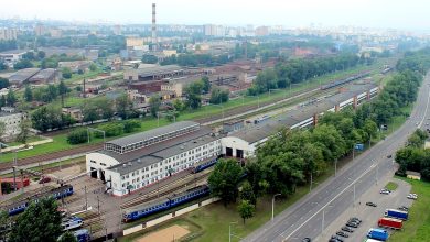 Вид сверху на депо, станционные пути с электропоездами и городскую застройку