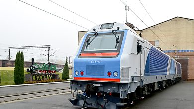 Грузовой электровоз в бело-синей окраске у здания депо