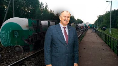 Мужчина в костюме у путей, рядом сошедшие с рельсов цистерны