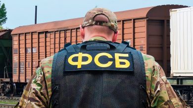 Сотрудник в бронежилете с надписью «ФСБ» у крытого вагона
