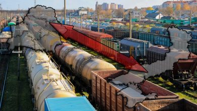Полувагоны и цистерны на станционных путях, контур карты Украины со стрелкой