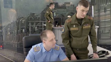 Диспетчер в форме железнодорожника и военнослужащий у пульта управления движением